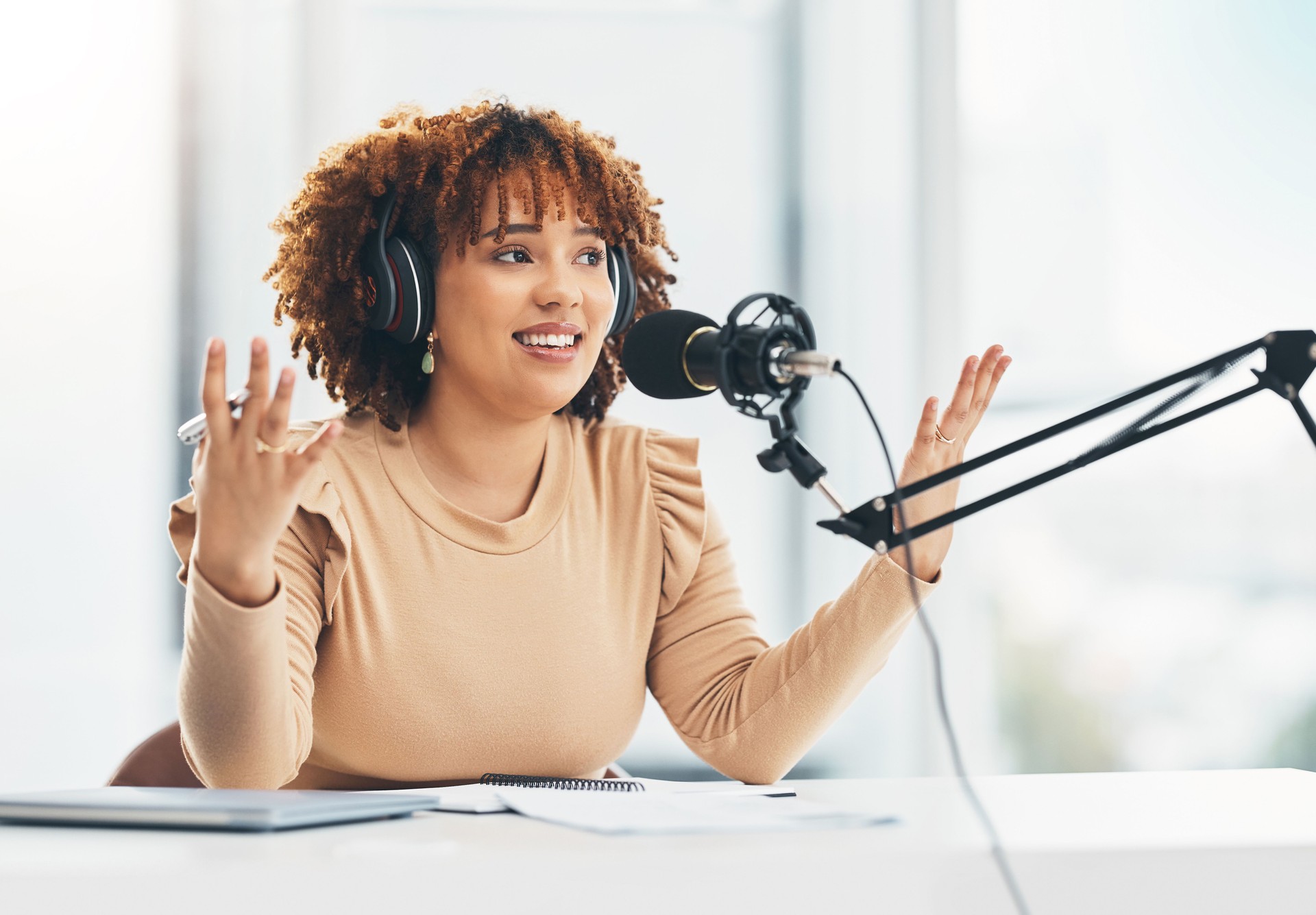 Radio show, podcast and black woman with microphone, talking and live streaming for advice. African American female presenter, lady or influencer with headphones, discussion or broadcast in workplace