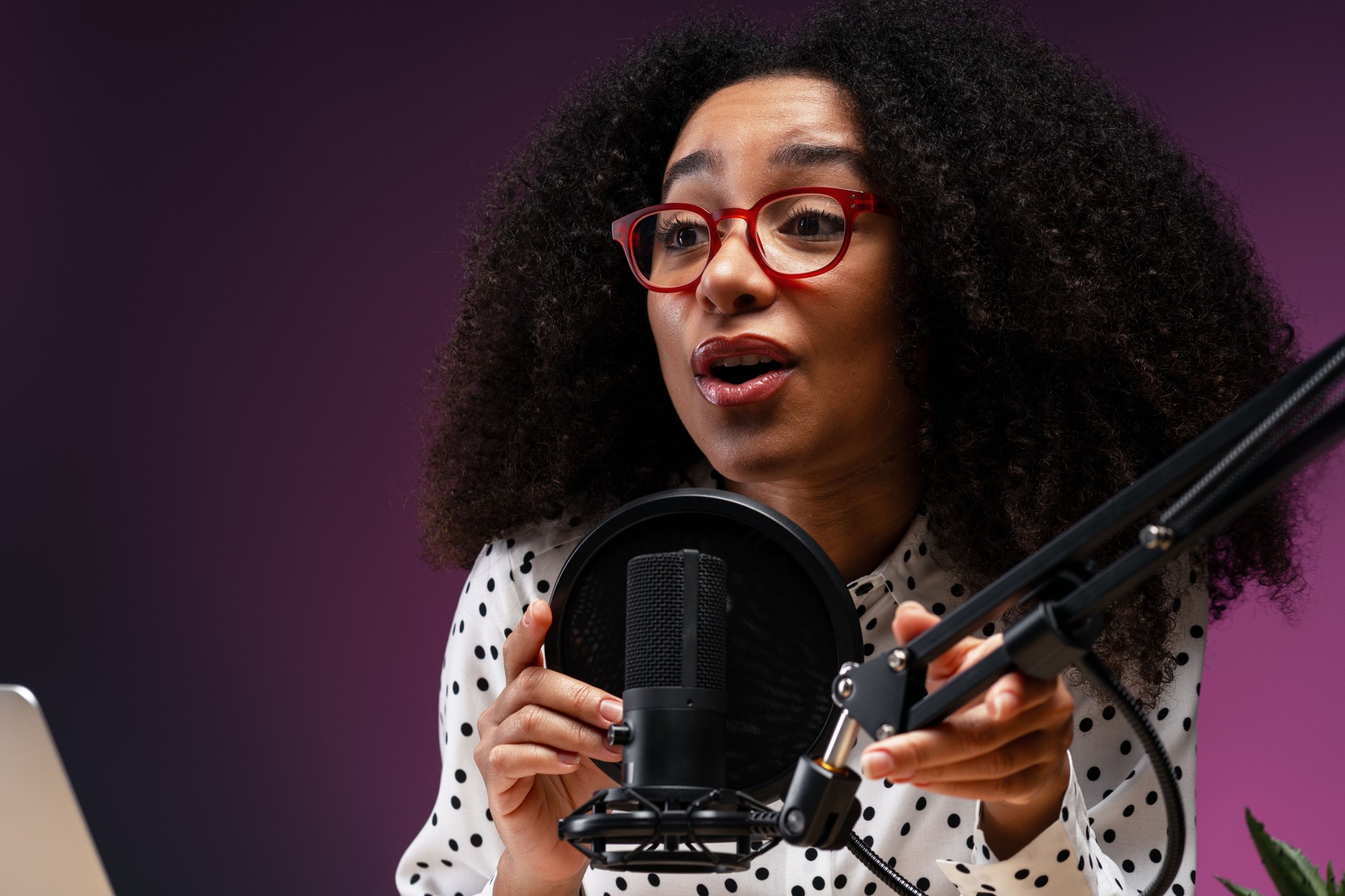 Young woman recording a podcast in a professional studio